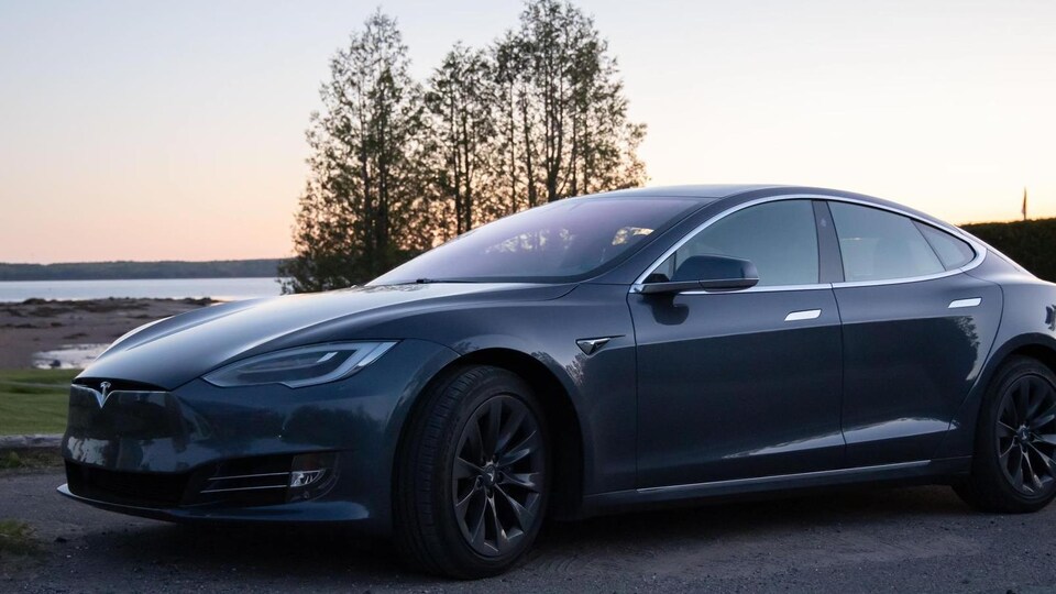 Une voiture électrique sur le bord de la mer.