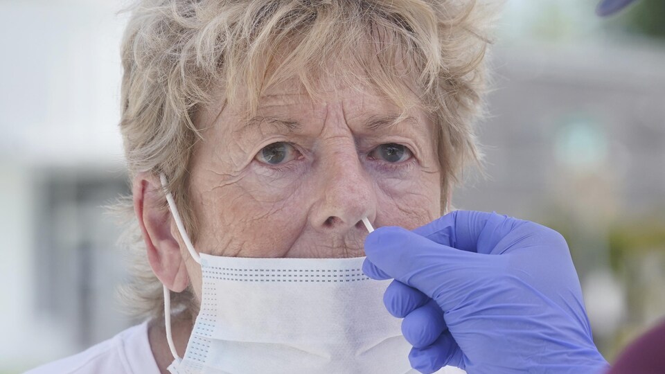 Un échantillon est prélevé de la narine d'une septuagénaire.