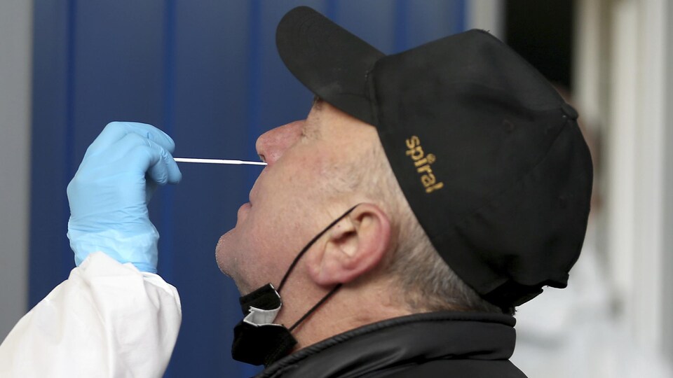Une infirmière prélève un échantillon de la narine d'un homme pour un test de dépistage de COVID-19 le 30 novembre 2020 à Vienne, en Autriche.