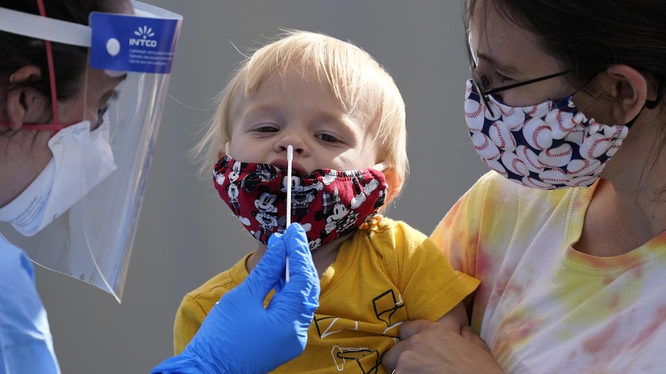 Une travailleuse de la santé effectue un test de dépistage auprès d'un enfant.