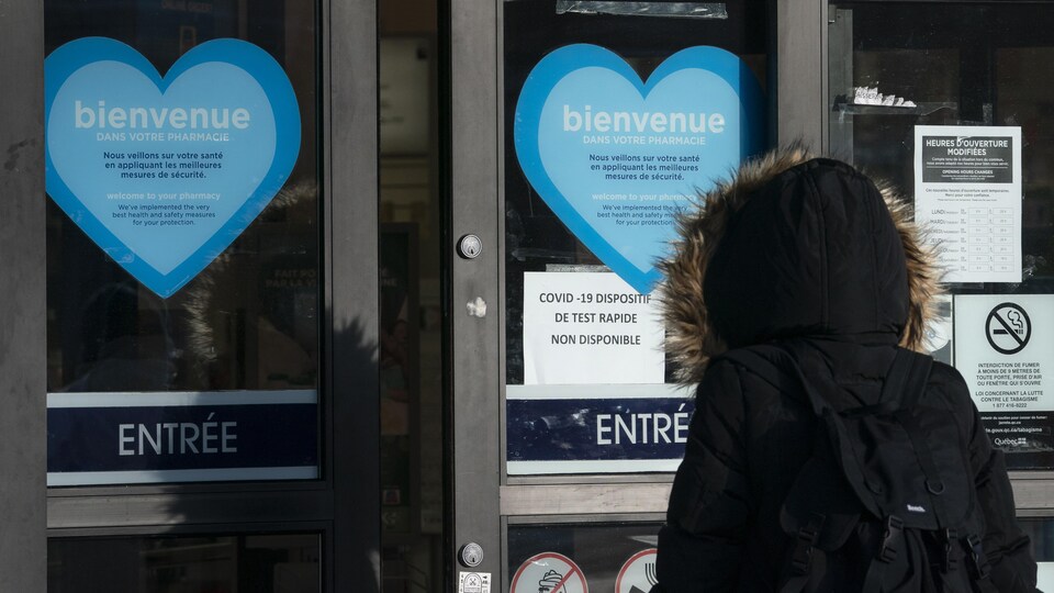 Une feuille collée sur la porte d'entrée d'une pharmacie indique que les tests rapides contre la COVID-19 ne sont pas offerts.