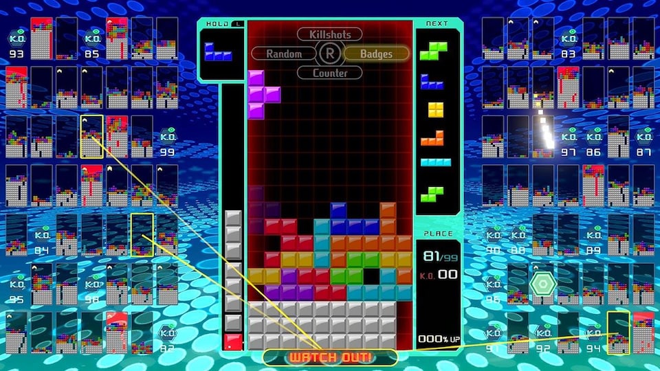 Une capture d'écran du jeu vidéo Tetris 99 montrant une pile de petits blocs colorés empilés les uns sur les autres sur une grille.