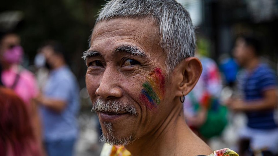 A glowing rainbow painted the face of a member of the LGBTQ+ community.