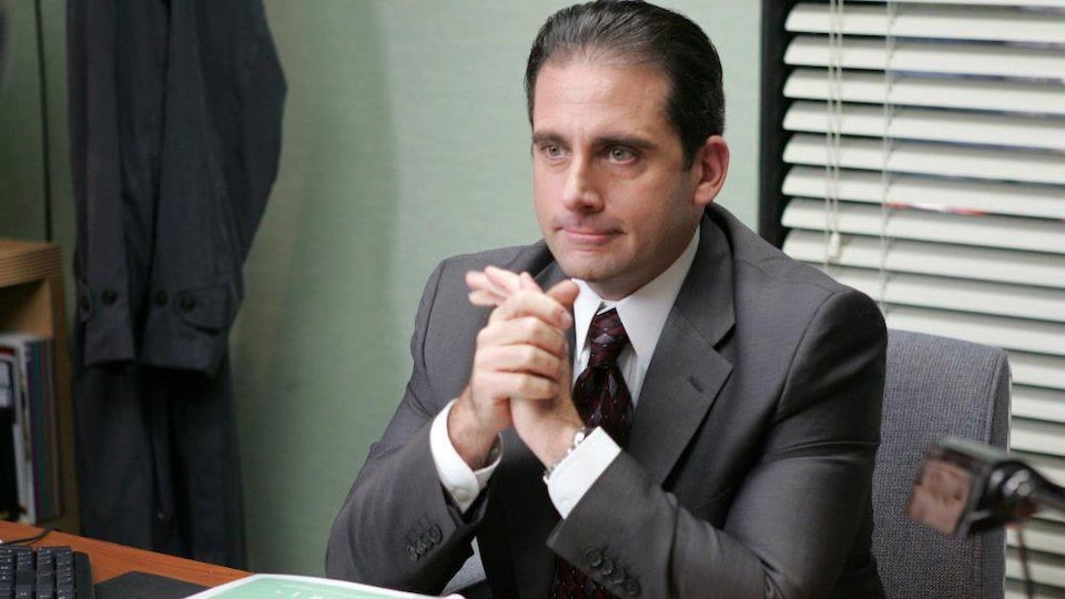 Un homme en complet-cravate assis à son bureau, le regard vers l'avant.