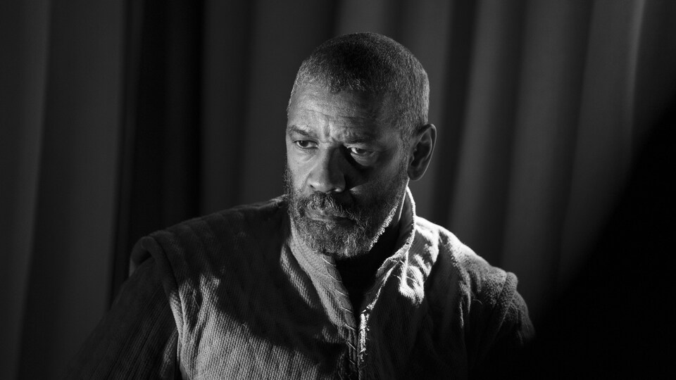 Dans la photo en noir et blanc, portrait de l'homme qui regarde vers le sol.