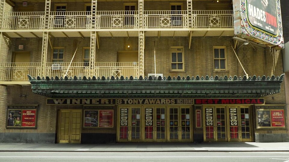La façade d'un bâtiment de plusieurs étages avec une rangée de portes au rez-de-chaussée et une enseigne annonçant une cérémonie de remise des prix Tony.