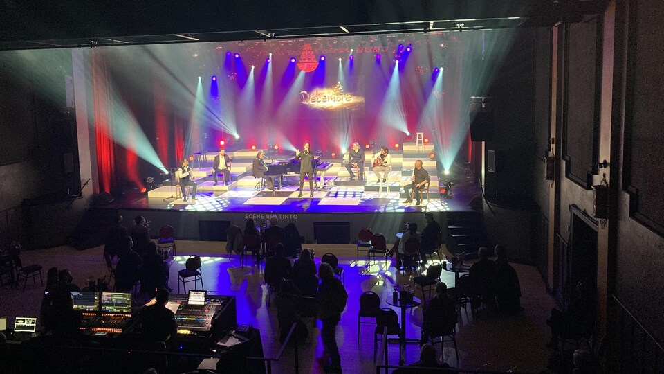 Des membres de Québec Issime donnent un spectacle devant une salle avec des spectateurs distanciés.