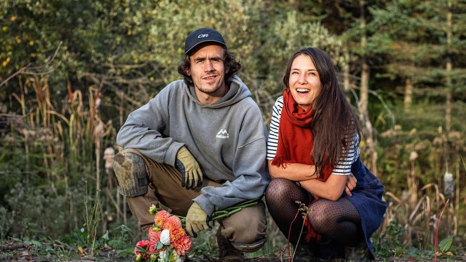 Thierry Bisaillon-Roy et Alice Berthe agenouillés devant une forêt, bouquet de fleurs à la main.