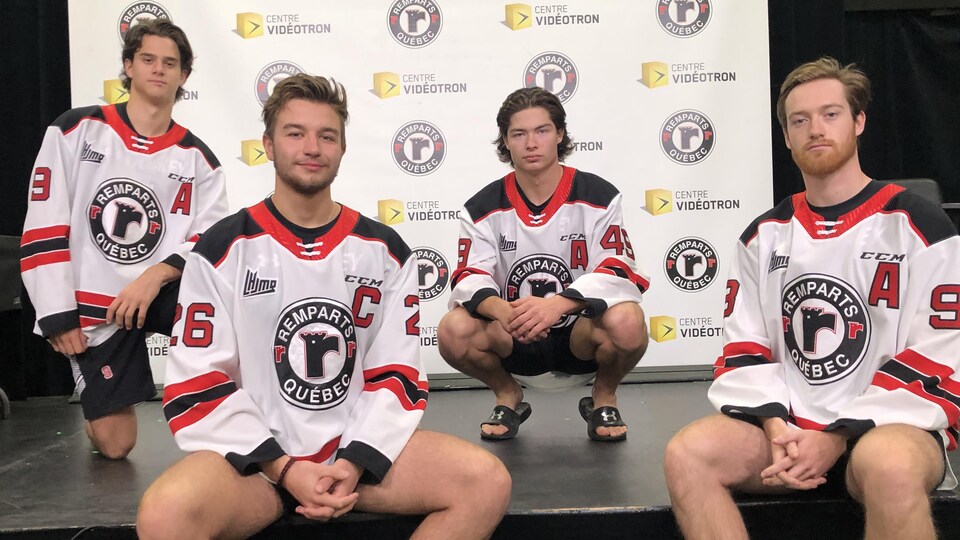 Théo Rochette, Thomas Caron, Édouard Cournoyer et Hunter Holmes posent dans leur chandail blanc des Remparts.
