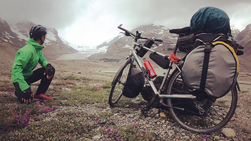 Un homme et un vélo devant les glaciers. 