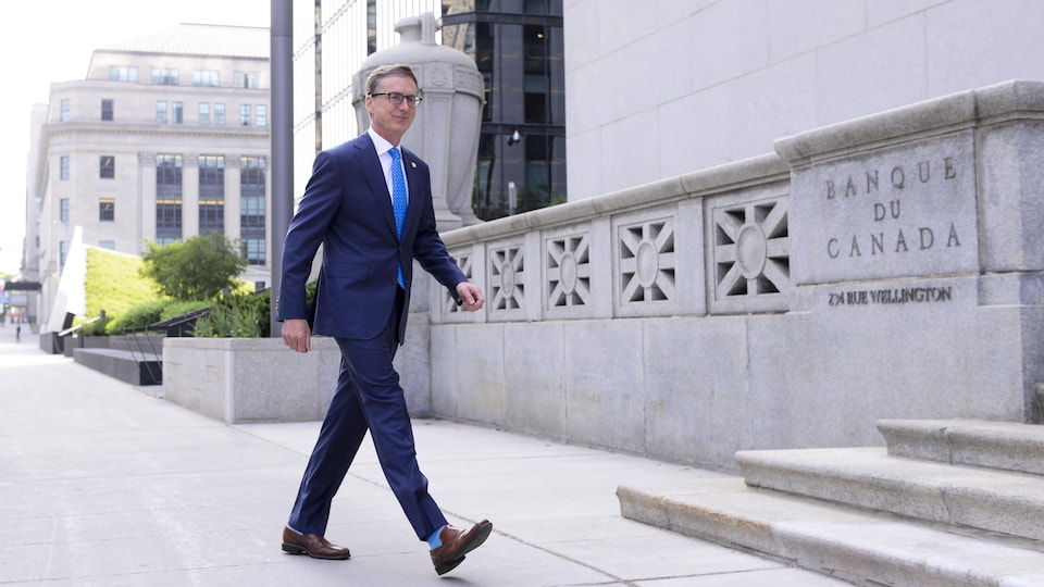 Tiff Macklem marche devant l'édifice de la Banque du Canada.