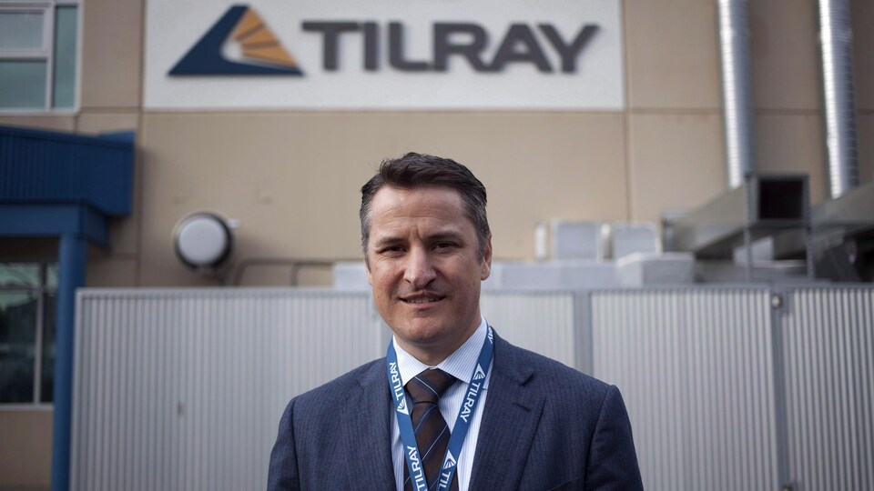 Portrait d'un homme devant une bâtiment qui porte le nom de l'entreprise