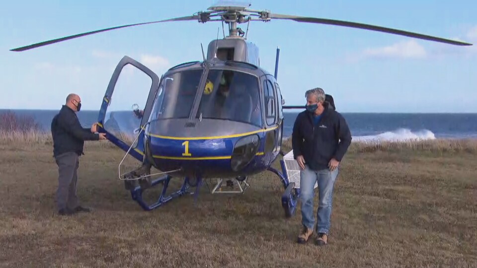 Le premier ministre de la Nouvelle-Écosse Tim Houston près d'un hélicoptère. La mer est derrière. 
