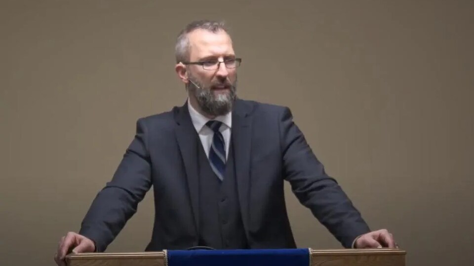 Le pasteur Tim Stephens de l'Église baptiste Fairview se tient debout devant un pupitre lors d'un sermon.
