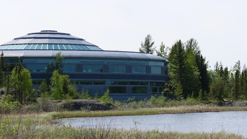 Un bâtiment en forme de dôme à côté d'un lac.