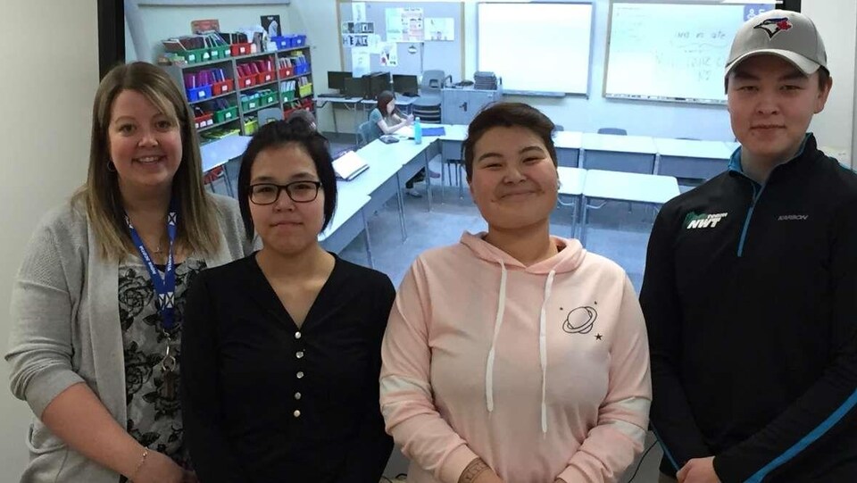Les trois élèves et leur accompagnatrice devant un écran