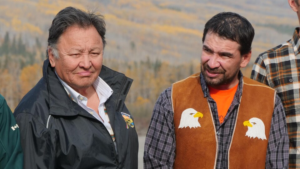 Herb Norwegian et Steve Vital côte-à-côte, l'un portant un manteau et l'autre, une veste en peau d'animal avec des têtes d'aigle brodés, le 30 septembre 2022 à Nahanni Butte.