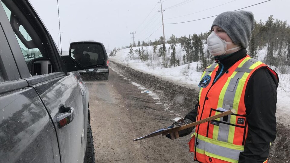 Un contrôle routier pendant lequel une agente chargée de faire respecter les règles pose des questions à des automobilistes.