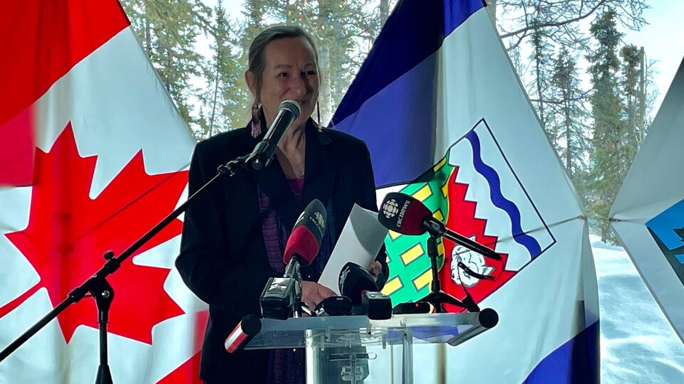 Caroline Cochrane devant les drapeaux du Canada et des Territoires du Nord-Ouest, le 29 mars 2023, à Yellowknife.