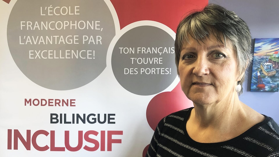 La directrice générale de la Commission scolaire francophone des Territoires du Nord-Ouest, Yvonne Careen, posée à l'intérieur, devant une bannière, le 17 août 2022.