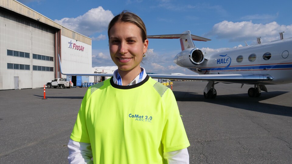 Nina Burgtorfer pose devant un avion lors des portes ouvertes de la NASA à Yellowknife, le 16 août 2022.