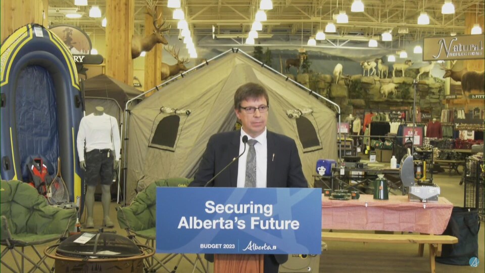 Un homme derrière un podium dans un magasin de plein air.