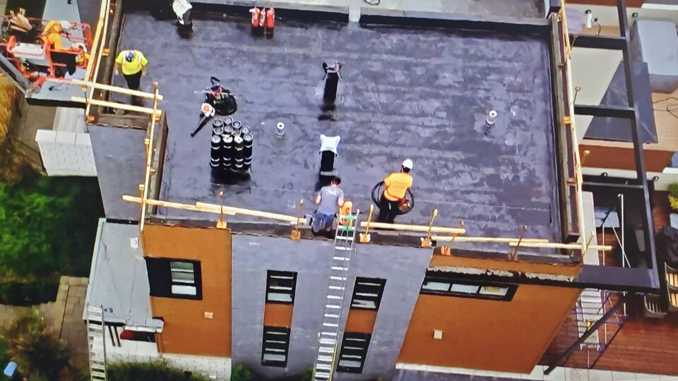 Des ouvriers sur un toit.