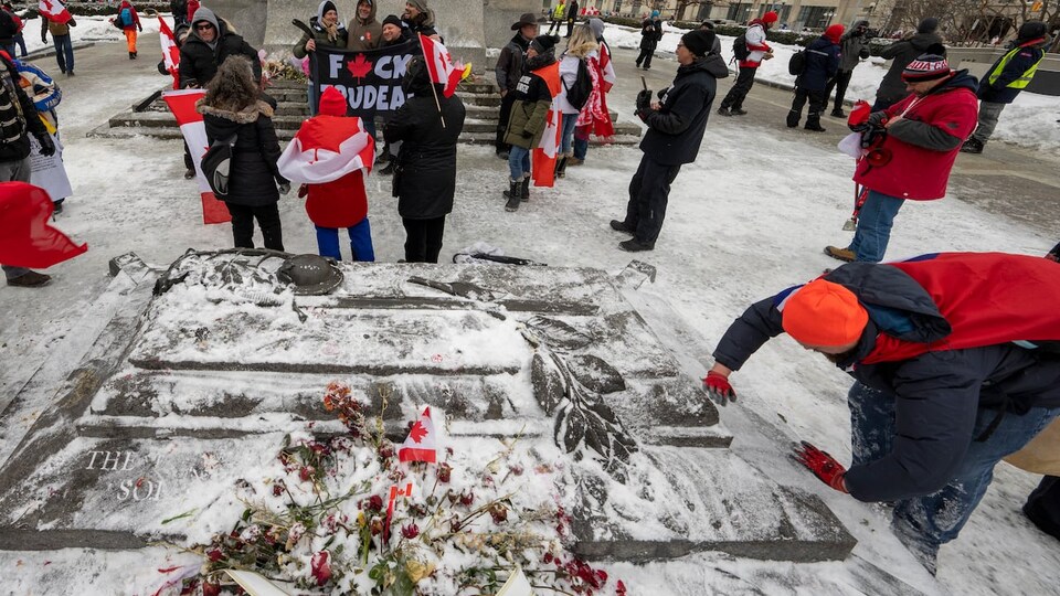 People posed with flags in front of the monument in the foreground.