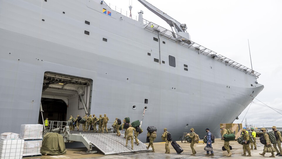 Des soldats entrent dans un navire.