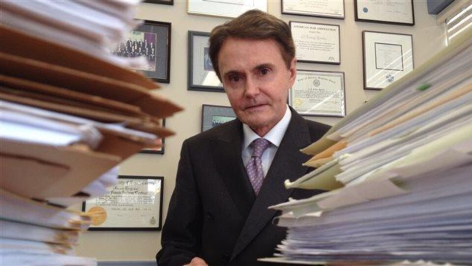 L'avocat Tony Merchant, pose dans son bureau avec un regard sérieux.