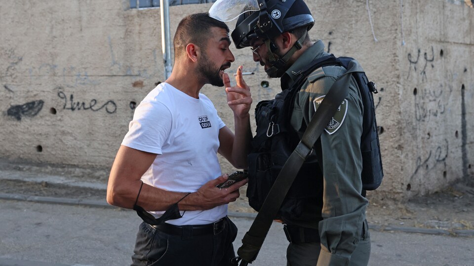 Un Palestinien se dispute avec un membre des forces de sécurité israélienne.