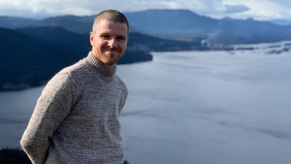 Jon Keough devant un paysage de collines et d'eau.