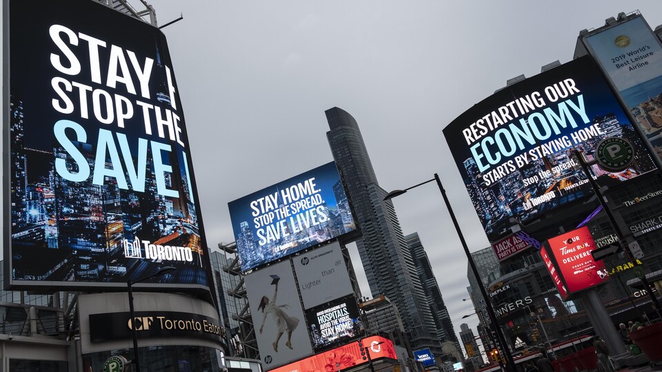 La Ville de Toronto presse les gens de rester à la maison sur les panneaux d'affichage du square Dundas.