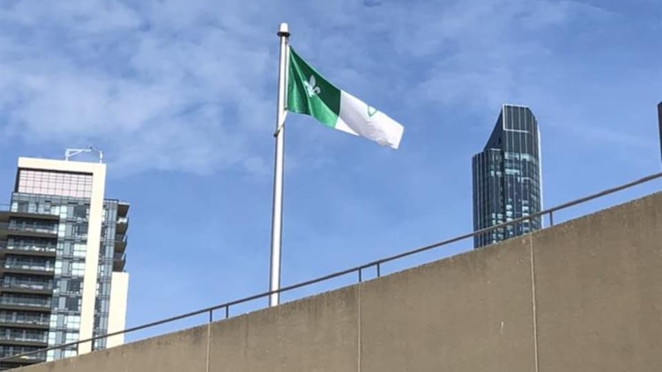 Un drapeau flotte à Toronto, à côté de deux tours. 