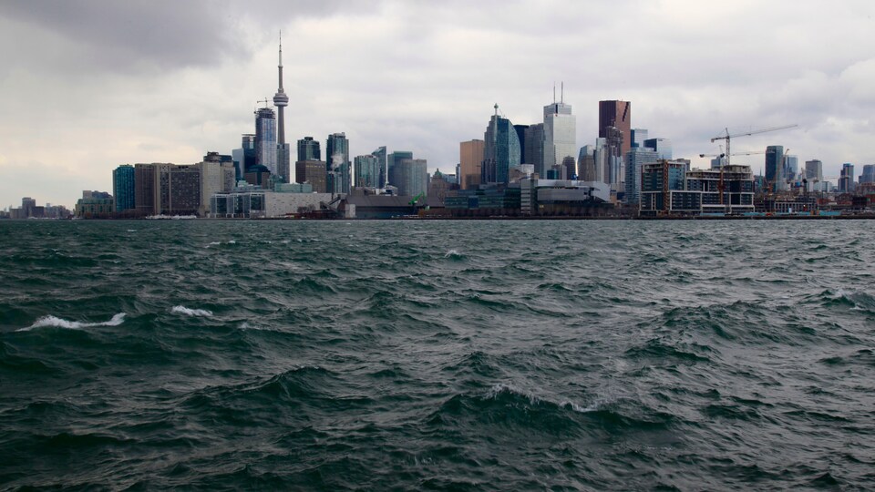 Vue du centre-ville de Toronto, la Tour du CN et les gratte-ciels à partir du Lac Ontario, une journée grise et nuageuse.