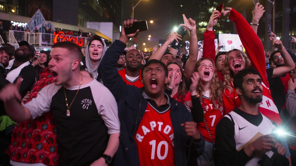 Des partisans célèbrent la victoire des Raptors de Toronto.