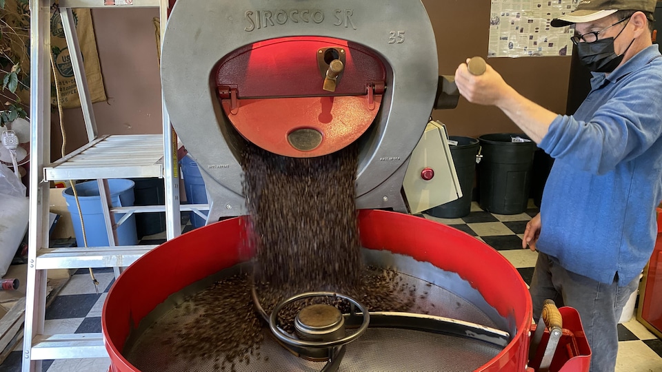 Une machine qui torréfie le café et un homme qui la manie.