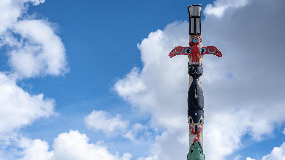Un totem sur fond de ciel parsemé de nuages.