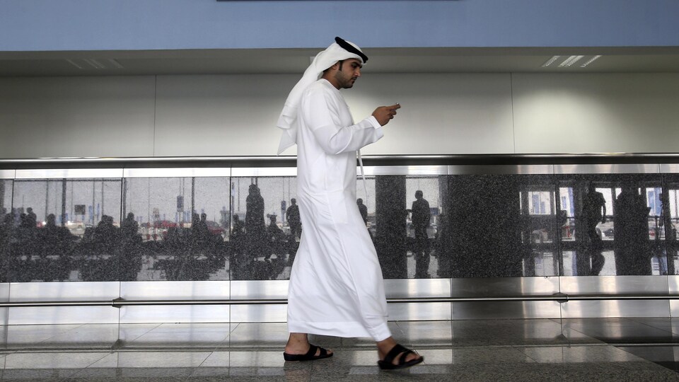 Un homme regarde son téléphone aux Émirats arabes unis.