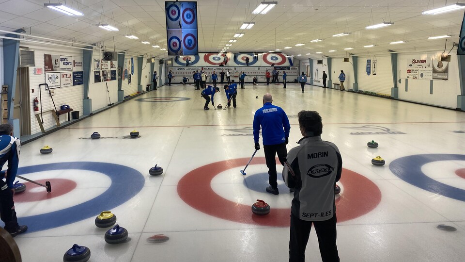 Des gens jouent au curling.