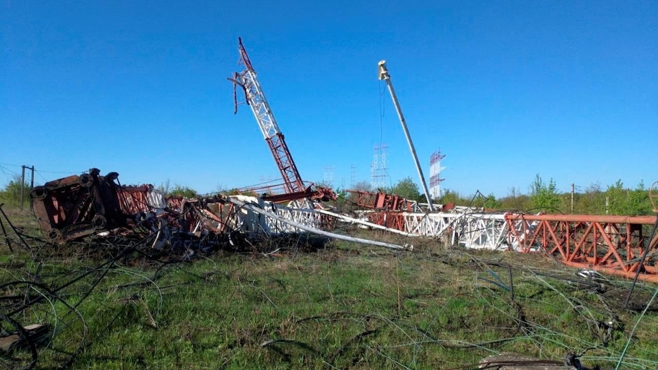 Two destroyed radio towers, on the ground. 