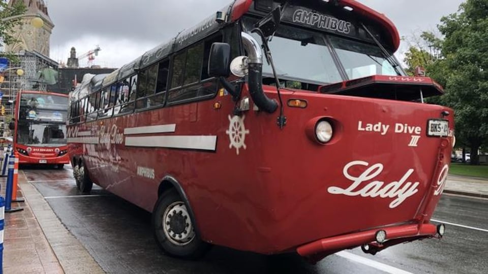Un autobus touristique stationné au centre-ville d'Ottawa, près de la colline du Parlement.