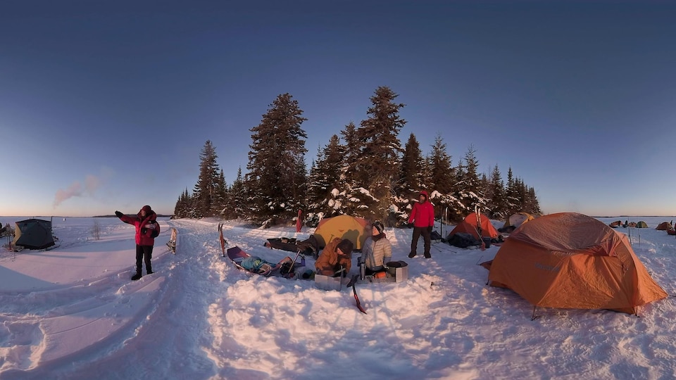 Des gens qui font du camping d'hiver sur un lac.