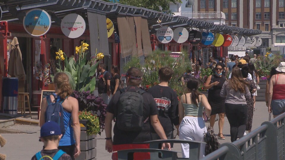 Des touristes devant une rangée de boutiques.