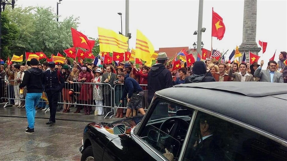 Un lieu de tournage où des manifestants brandissent des drapeaux américains et vietnamiens.