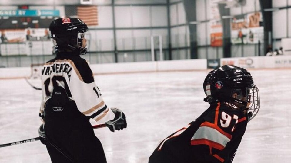 Deux joueurs de hockey sur la patinoire.
