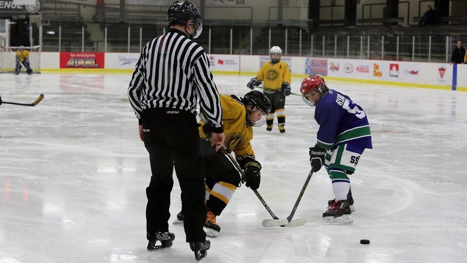 Mise au jeu au centre de la glace au Tournoi de hockey pee-wee de Jonquière.