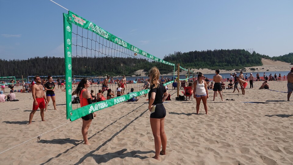 Des gens jouent une partie de volleyball sur une plage