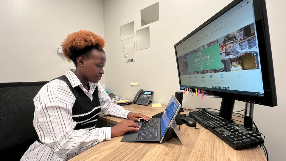 Tracy Karuhogo travaille sur un ordinateur portable dans un bureau.