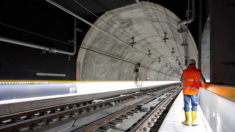 Chemin ferroviaire avec un homme portant un uniforme de construction.